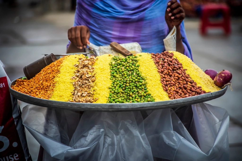 Street food vendor serving customers in an Indian market, representing Udaipur's small businesses