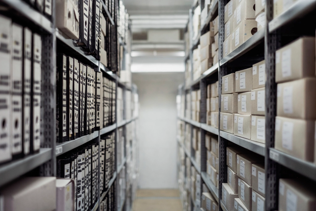 Warehouse aisle with labeled boxes stacked on inventory shelves